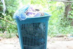 Pile of clothes overflow plastic laundry basket for washing photo