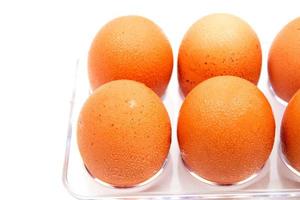 Eggs form refrigerator with water droplets on white background. photo