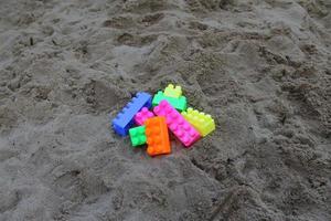 plastic building blocks on sand background. photo