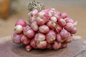 Shallots still on wood background photo