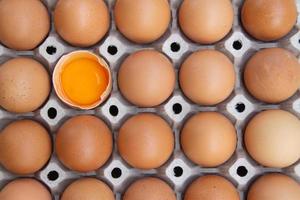 The brown eggs are broken in the tray. Arrange the eggs in the tray. The eggs are in the paper tray. photo