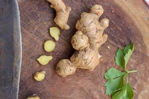 Ginger root sliced on wooden background photo