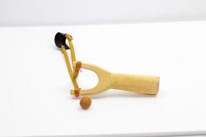 Handmade slingshot catapult. Y-shaped wooden stick with elastic tied between two top parts. Slingshot or Catapult is device for shooting small stones. photo