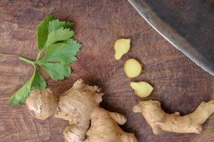 Ginger root sliced on wooden background photo