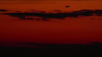 de flygplan på de slutlig närma sig innan landning på de bakgrund av de solnedgång skymning himmel video