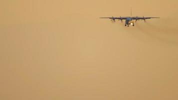 Military airfreighter on final approach before landing with sunset sky on the background. Novosibirsk video