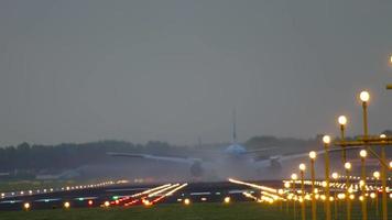 vista panorámica de un avión que llega al aeropuerto y aterriza en una pista ancha al atardecer. aterrizaje de avión de pasajeros video