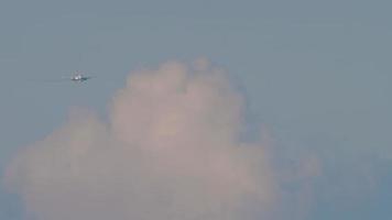 lång skott av passagerare flygplan närmar sig till landa i en molnig himmel. trafikflygplan silhuett är flygande. turism och luft resa begrepp video