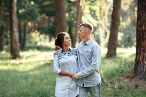 hombre y mujer joven alegre se abrazan al aire libre en el parque de verano. Citas y vacaciones románticas. pareja enamorada mirándose suavemente el uno al otro en un día soleado. el amor y las relaciones entre los jóvenes foto