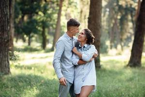 hombre y mujer joven alegre se abrazan al aire libre en el parque de verano. Citas y vacaciones románticas. pareja enamorada mirándose suavemente el uno al otro en un día soleado. el amor y las relaciones entre los jóvenes foto