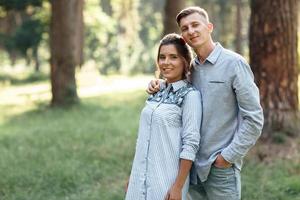 hombre y mujer joven alegre se abrazan al aire libre en el parque de verano. pareja enamorada que tiene cita y vacaciones románticas en un día soleado. el amor y las relaciones entre los jóvenes foto