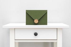 green envelope with designer cardboard and seal on a white background. Envelope with seal photo