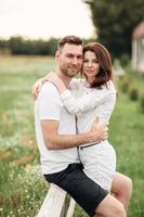 beautiful young couple hugging and having fun outdoors in the park on a warm summer sunny day photo