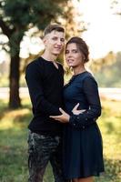 hombre y mujer joven alegre se abrazan al aire libre en el parque de verano. pareja enamorada que tiene cita y vacaciones románticas al atardecer. el amor y las relaciones entre los jóvenes foto