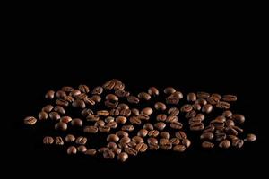 scattered coffee beans. fragrant coffee on the table. coffee is large. coffee on a black background. place for text photo