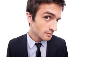 Who is there Wide-angle image of young man in formalwear looking at camera while standing isolated on white background photo