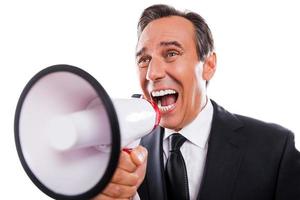 Can you hear me Furious mature man in formalwear shouting at megaphone while standing isolated on white background photo