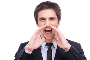 Great news Happy young man in formalwear shouting while looking at camera and standing isolated on white background photo