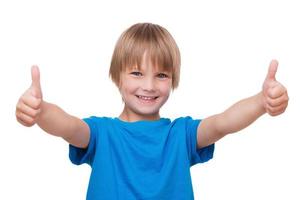 Thumbs up Happy little boy showing his thumbs up and smiling while standing isolated on white photo