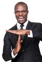 Time out Furious young African man in formalwear gesturing time out while standing isolated on white background photo