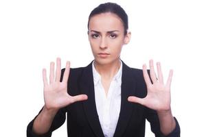 Stop Confident young woman in formalwear looking at camera and showing her palms while standing isolated on white background photo