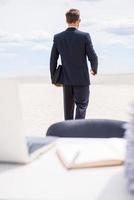 I am quit Rear view of man in formalwear walking away from his working place photo