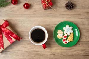 feliz navidad con galletas caseras y taza de café sobre fondo de mesa de madera. concepto de víspera de navidad, fiesta, vacaciones y feliz año nuevo foto