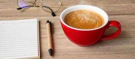 blank notebook and coffee cup on wood table. Motivation, Resolution, To do list, Strategy and Plan concept photo