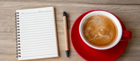 blank notebook and coffee cup on wood table. Motivation, Resolution, To do list, Strategy and Plan concept photo