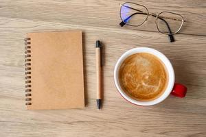 blank notebook and coffee cup on wood table. Motivation, Resolution, To do list, Strategy and Plan concept photo