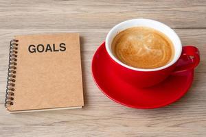 GOAL with notebook and coffee cup on wood table. Motivation, Resolution, To do list, Strategy and Plan concept photo