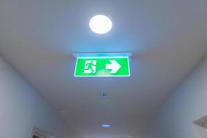 Fire Emergency exit sign on the wall background inside building. Safety concept photo