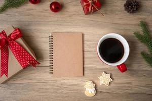 Blank notebook, black coffee cup, Christmas cookies and pen on wood table, Top view and copy space. Xmas, Happy New Year, Goals, Resolution, To do list, Strategy and Plan concept photo