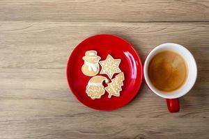 feliz navidad con galletas caseras y taza de café sobre fondo de mesa de madera. concepto de víspera de navidad, fiesta, vacaciones y feliz año nuevo foto