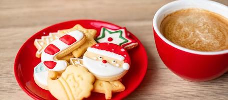 feliz navidad con galletas caseras y taza de café sobre fondo de mesa de madera. concepto de víspera de navidad, fiesta, vacaciones y feliz año nuevo foto