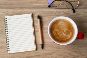 blank notebook and coffee cup on wood table. Motivation, Resolution, To do list, Strategy and Plan concept photo