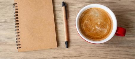 blank notebook and coffee cup on wood table. Motivation, Resolution, To do list, Strategy and Plan concept photo