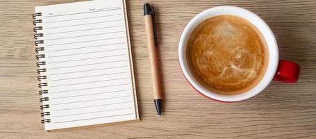 blank notebook and coffee cup on wood table. Motivation, Resolution, To do list, Strategy and Plan concept photo