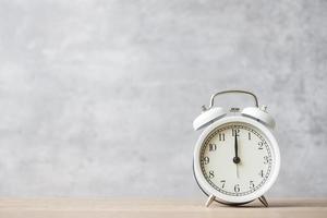 Vintage alarm clock on wooden table background and copy space for text. Activity, daily routine, morning, countdown, workout and Work life balance concept photo