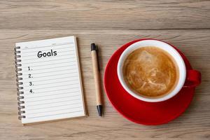 GOAL with notebook and coffee cup on wood table. Motivation, Resolution, To do list, Strategy and Plan concept photo