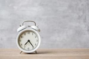 Vintage alarm clock on wooden table background and copy space for text. Activity, daily routine, morning, countdown, workout and Work life balance concept photo