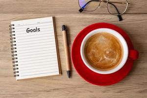 GOAL with notebook and coffee cup on wood table. Motivation, Resolution, To do list, Strategy and Plan concept photo