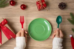Merry Christmas with plate, fork and spoon on wood table background. Xmas, party and happy New Year concept photo
