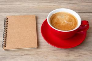 cuaderno en blanco y taza de café en la mesa de madera. motivación, resolución, lista de tareas, estrategia y concepto de plan foto