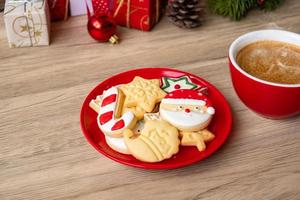 feliz navidad con galletas caseras y taza de café sobre fondo de mesa de madera. concepto de víspera de navidad, fiesta, vacaciones y feliz año nuevo foto