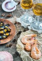 Seafood with two glasses of white wine on the wooden table photo