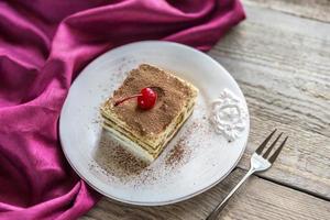 Tiramisu in the plate on the wooden background photo