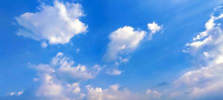Fondo de vista clara del cielo de color azul con nubes detrás del sol foto