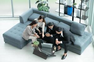 Young entrepreneurs in Asia Take a break to relax in the relaxation room after a meeting. By watching movies, taking photos, talking photo