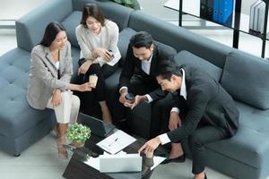 Young entrepreneurs in Asia Take a break to relax in the relaxation room after a meeting. By watching movies, taking photos, talking photo